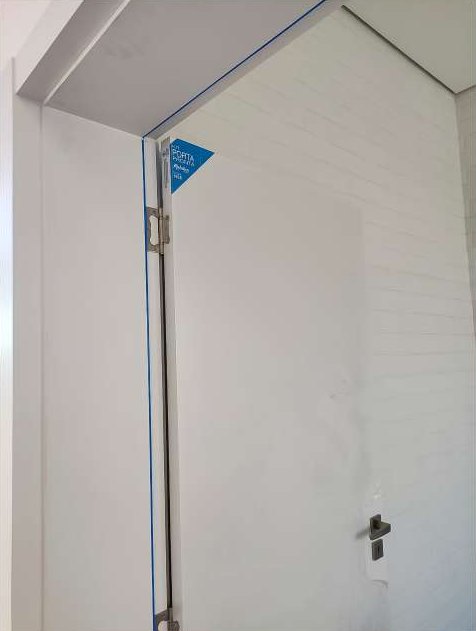 Detalhe do batente e da folha de uma porta branca instalada